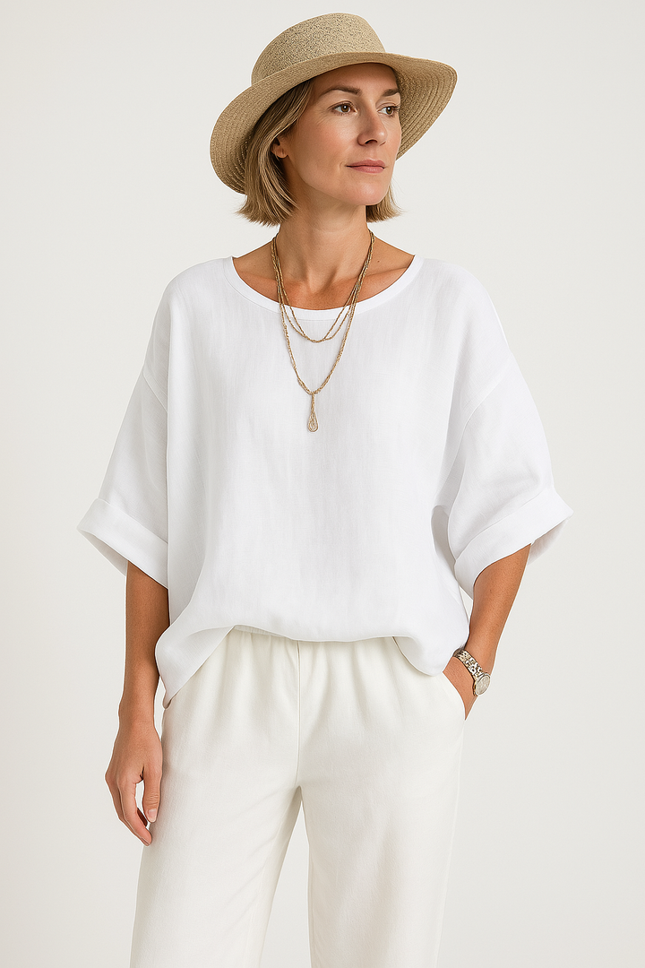 Woman wearing a white top and beige hat on a plain background