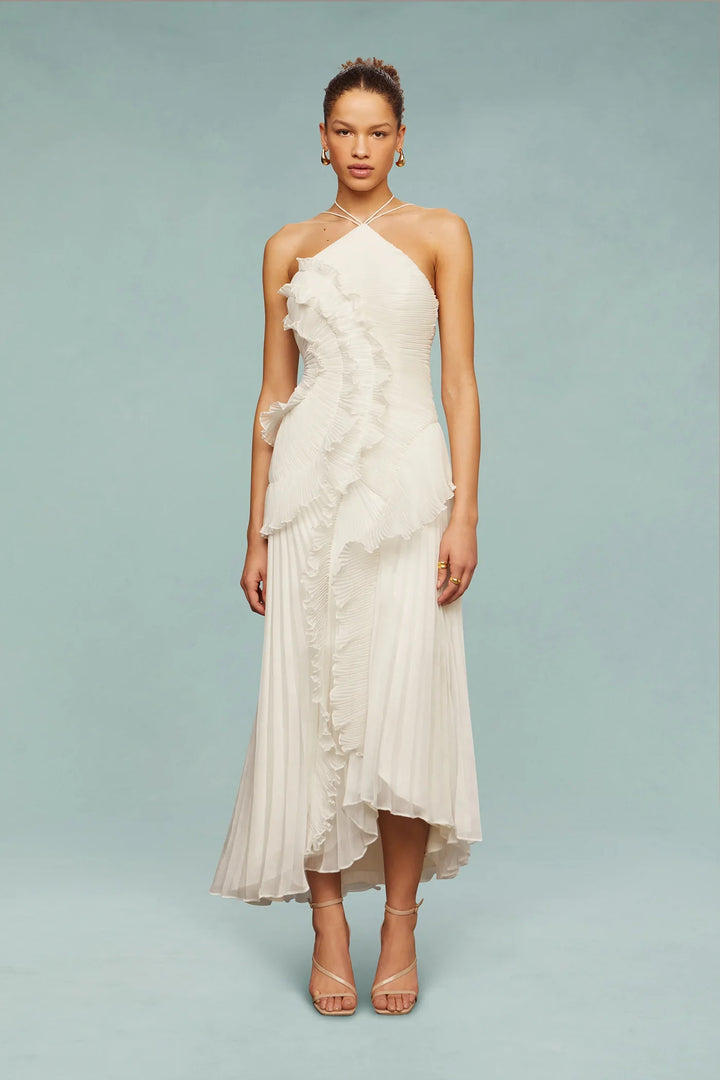 Woman wearing a white halter-neck dress with floral details on a light blue background