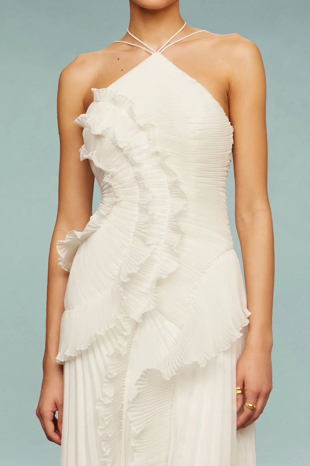 White ruffled halter neck dress on a plain background
