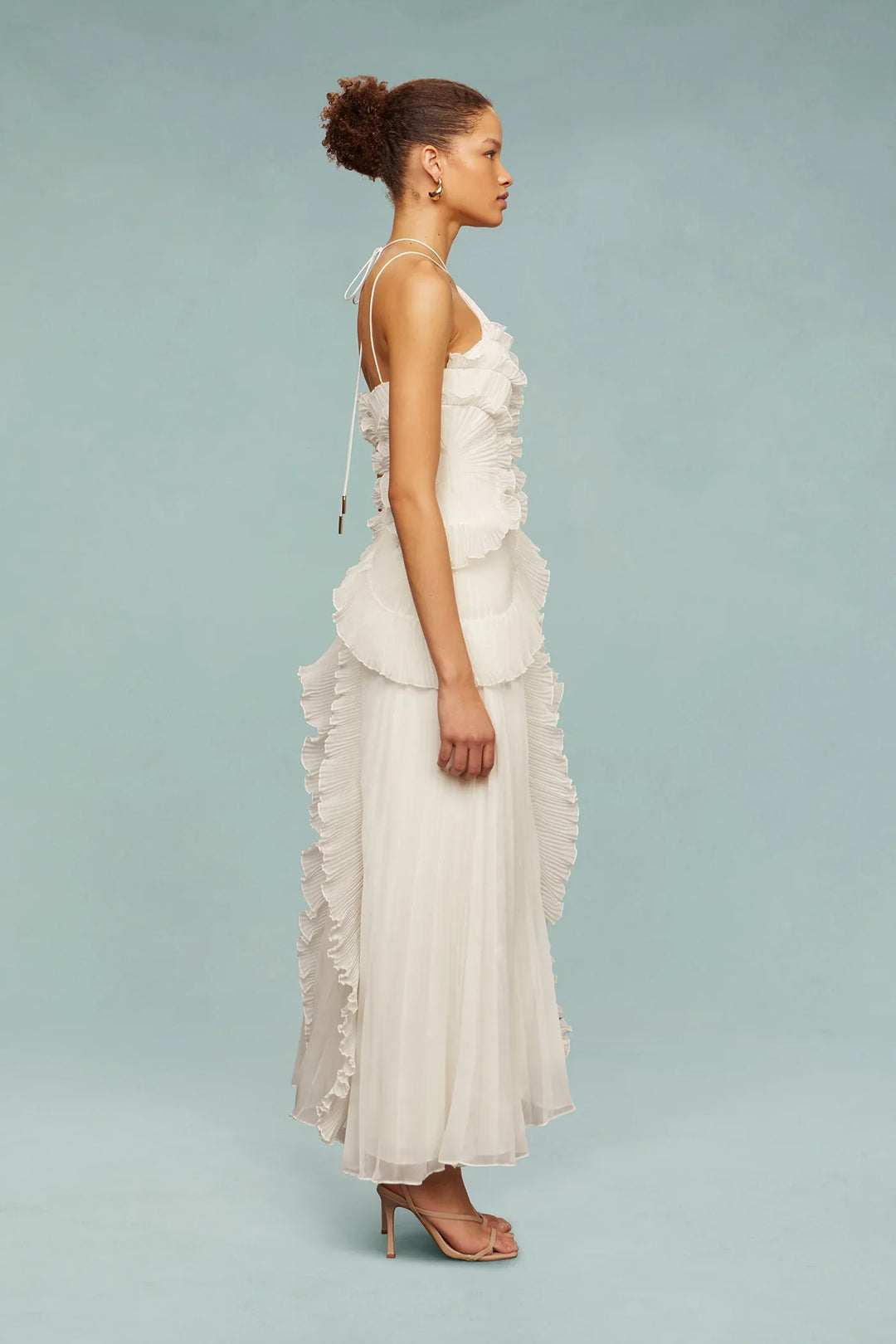 Woman wearing a white floral dress against a light blue background