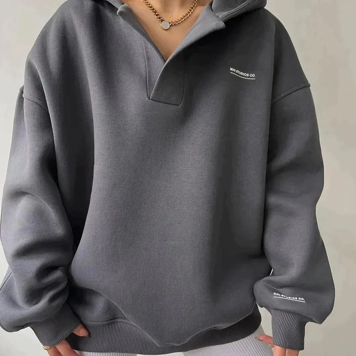 Gray sweatshirt with a brand logo on a neutral background